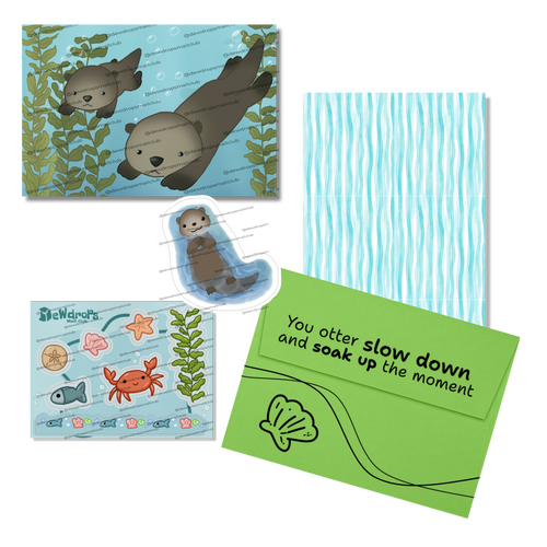 A coordinated set of ocean-themed stationery items including a die-cut otter sticker, a printed postcard with underwater artwork, a green envelope with a seashell illustration and text, a sticker sheet, and a blue-and-white striped paper sheet, arranged on a white background.